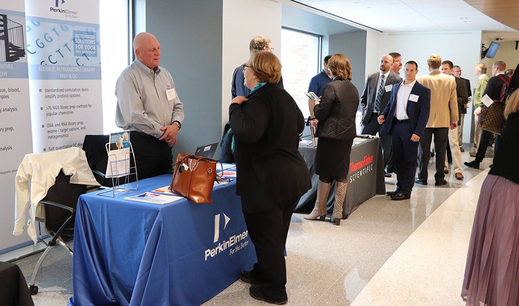 Photo of trade show with people interacting at a booth