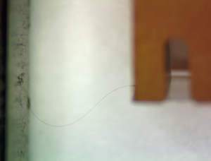 Image portraying how a diamond fiber looks like a strand of dark wavy hair